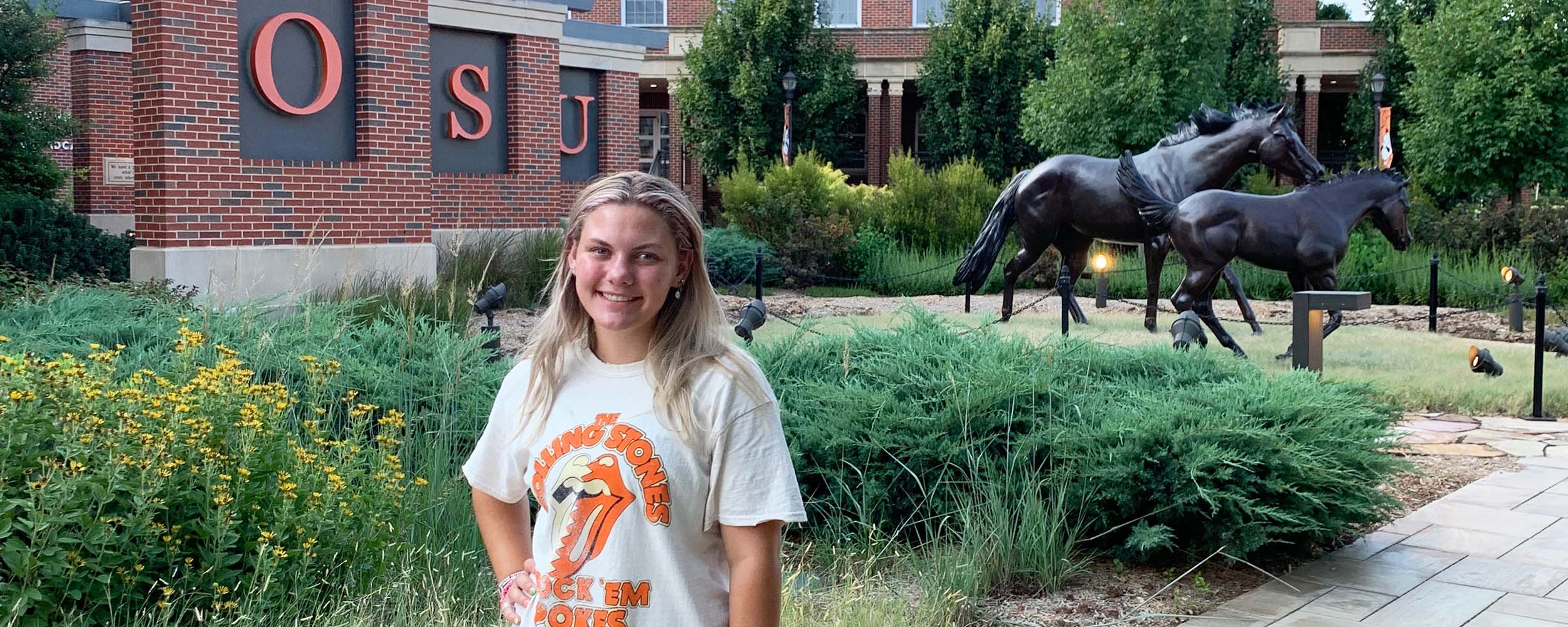 Camden Grizzle in front of the welcome plaza on the Oklahoma State campus.