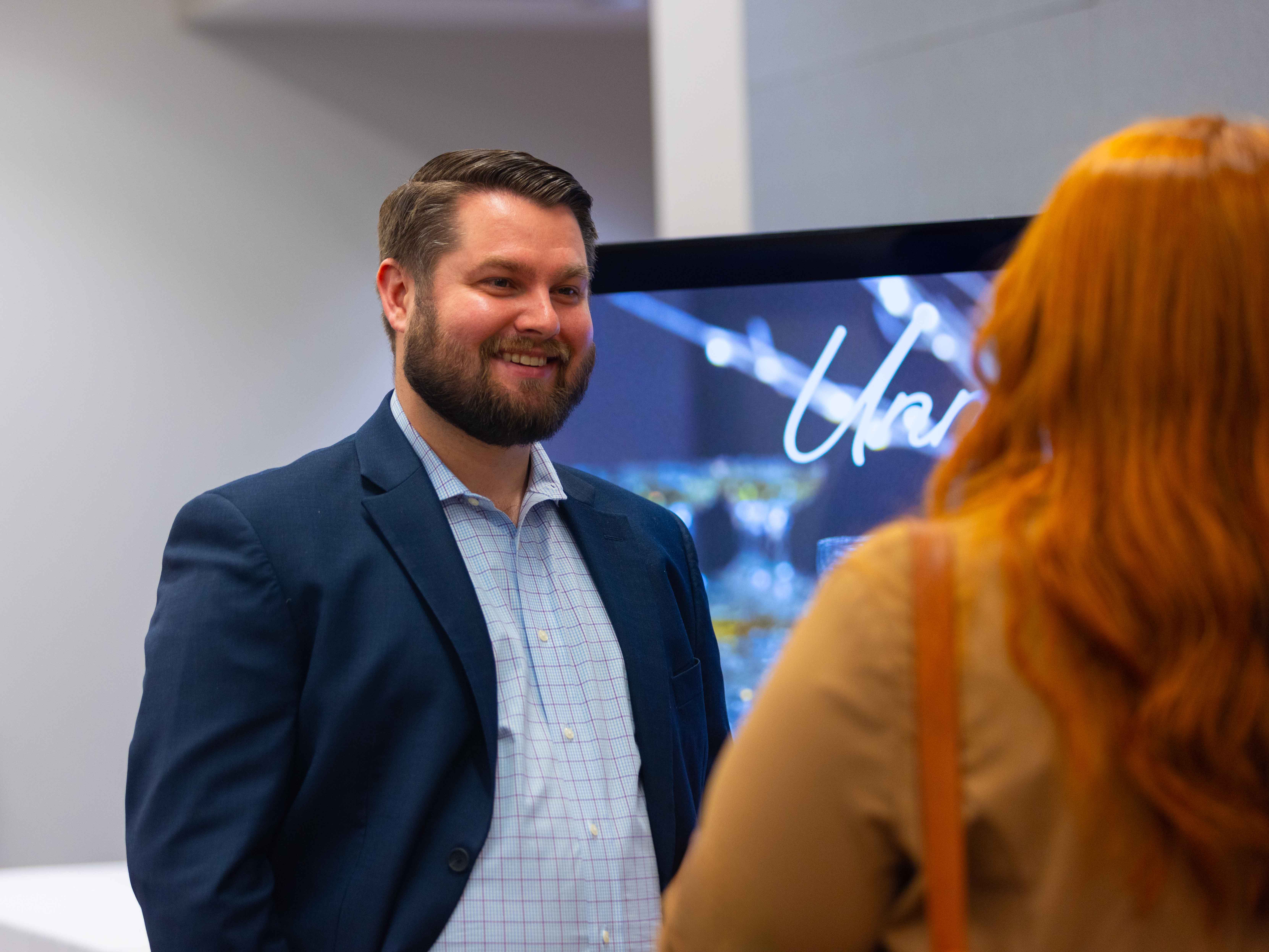 Male employer looks happy as he speaks to a student out of view at a career event.