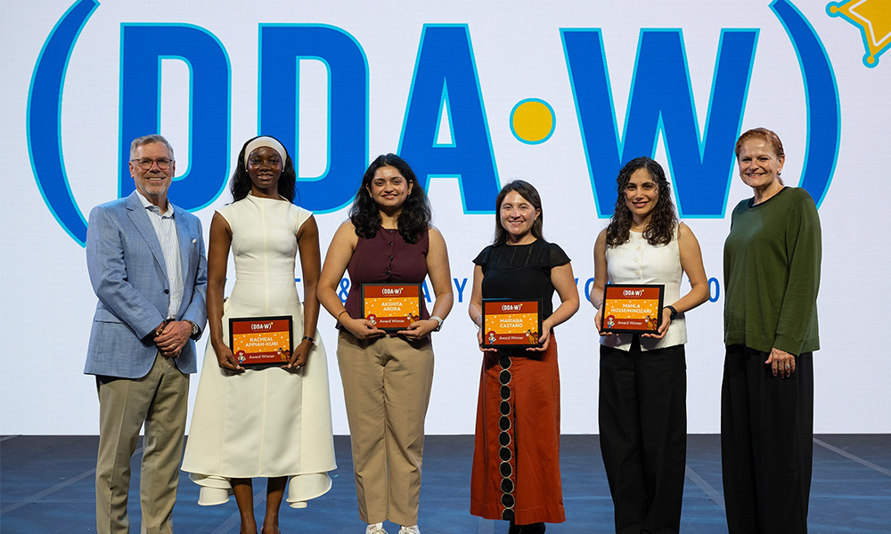 Spears Business students Mahla Hosseini and Racheal Appiah-Kubi accept their awards on stage at the Disney Data and Analytics Conference.