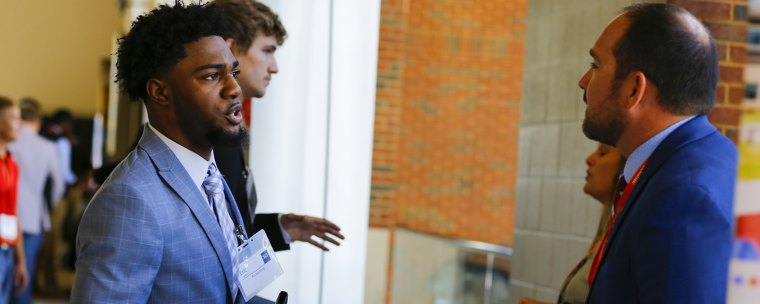 Student in business professional attire speaking with a recruiter. Student in business professional attire speaking with a recruiter.