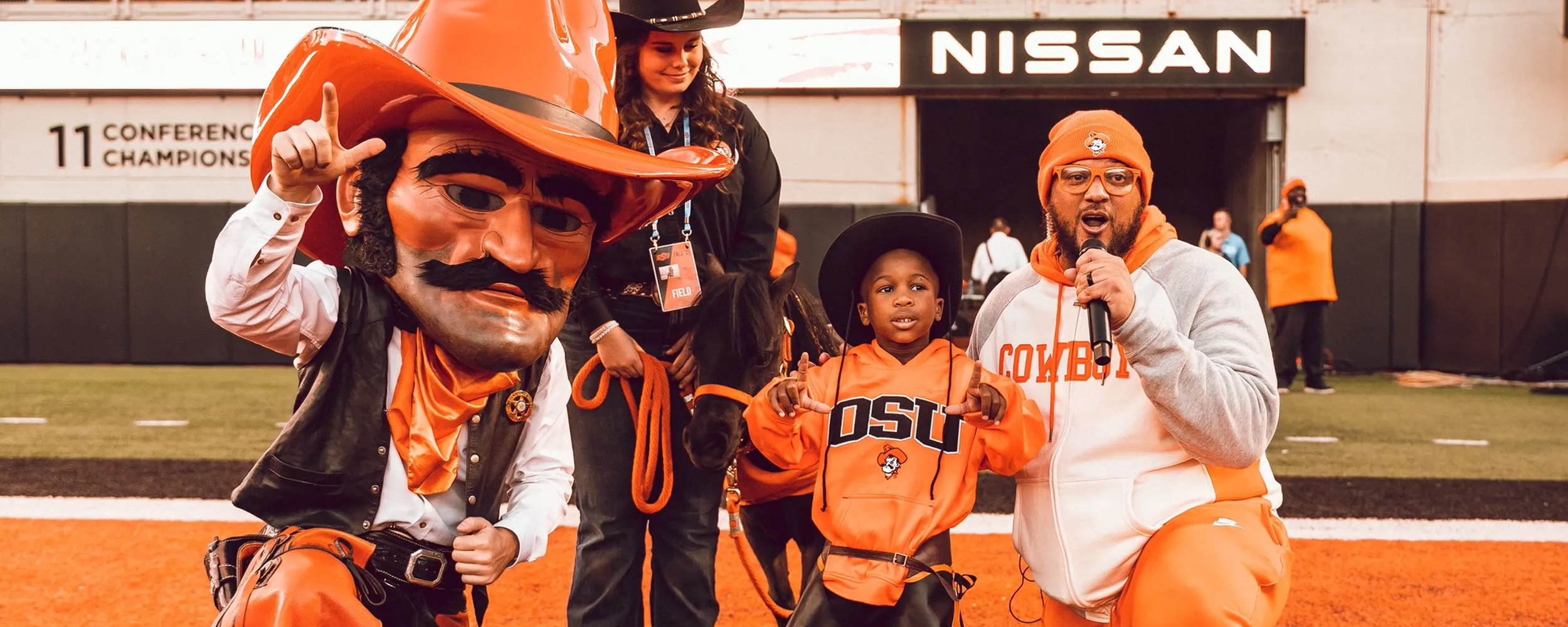 Pistol Pete, BB and handler, Warren the Cowboy and Les Thomas on the field in Boone Pickens Stadium. Pistol Pete, BB and handler, Warren the Cowboy and Les Thomas on the field in Boone Pickens Stadium.