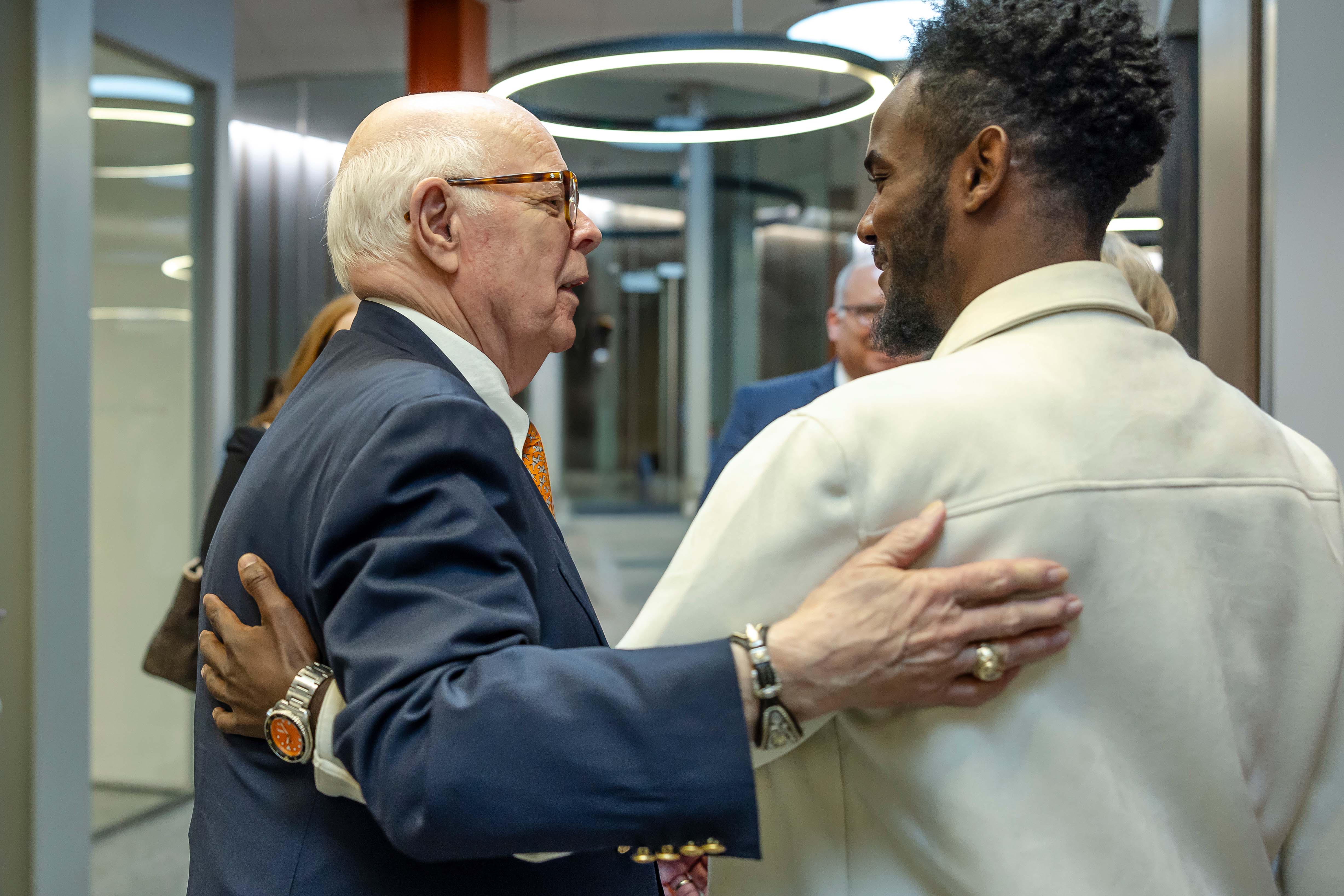 Dr. Spears with his arm around a male student having a conversation