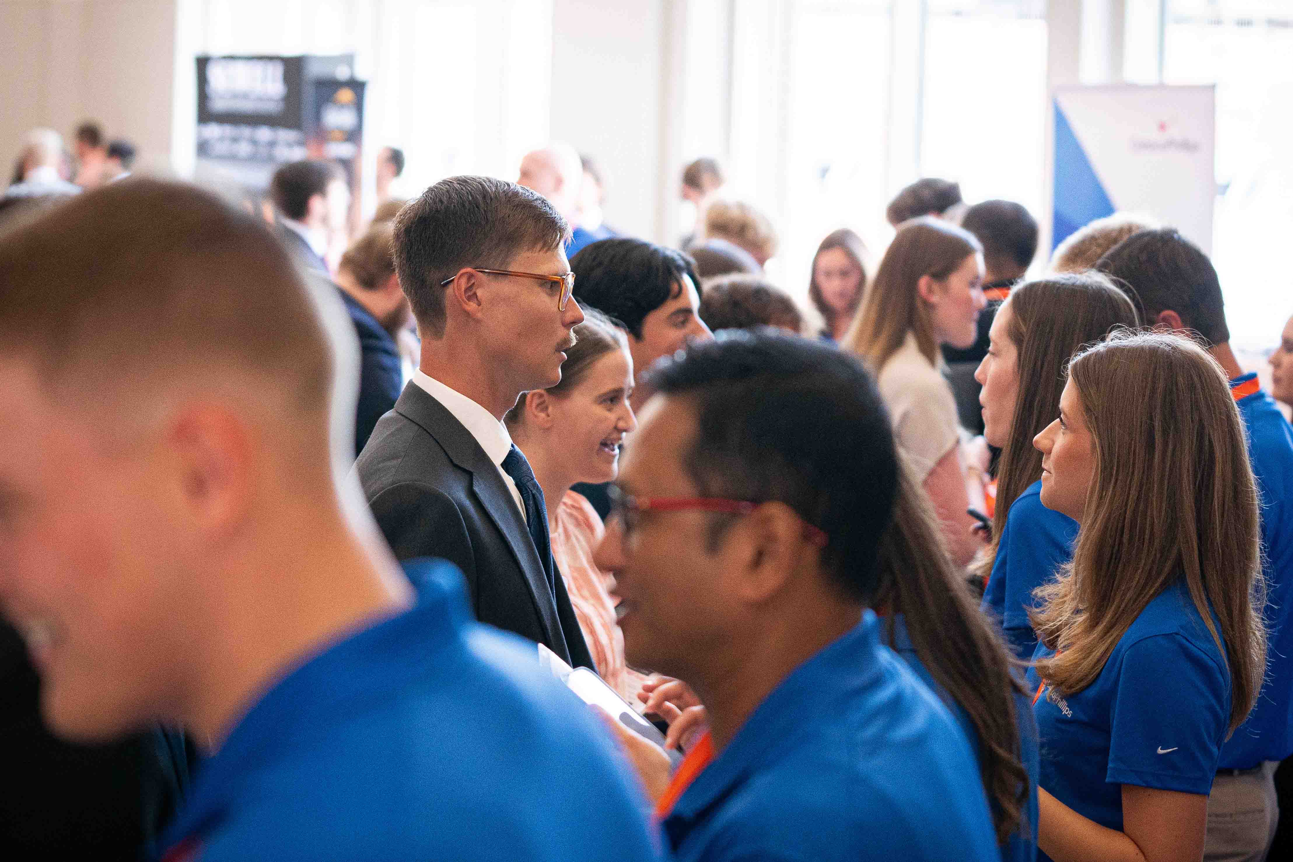 Several students speak to companies at a career fair