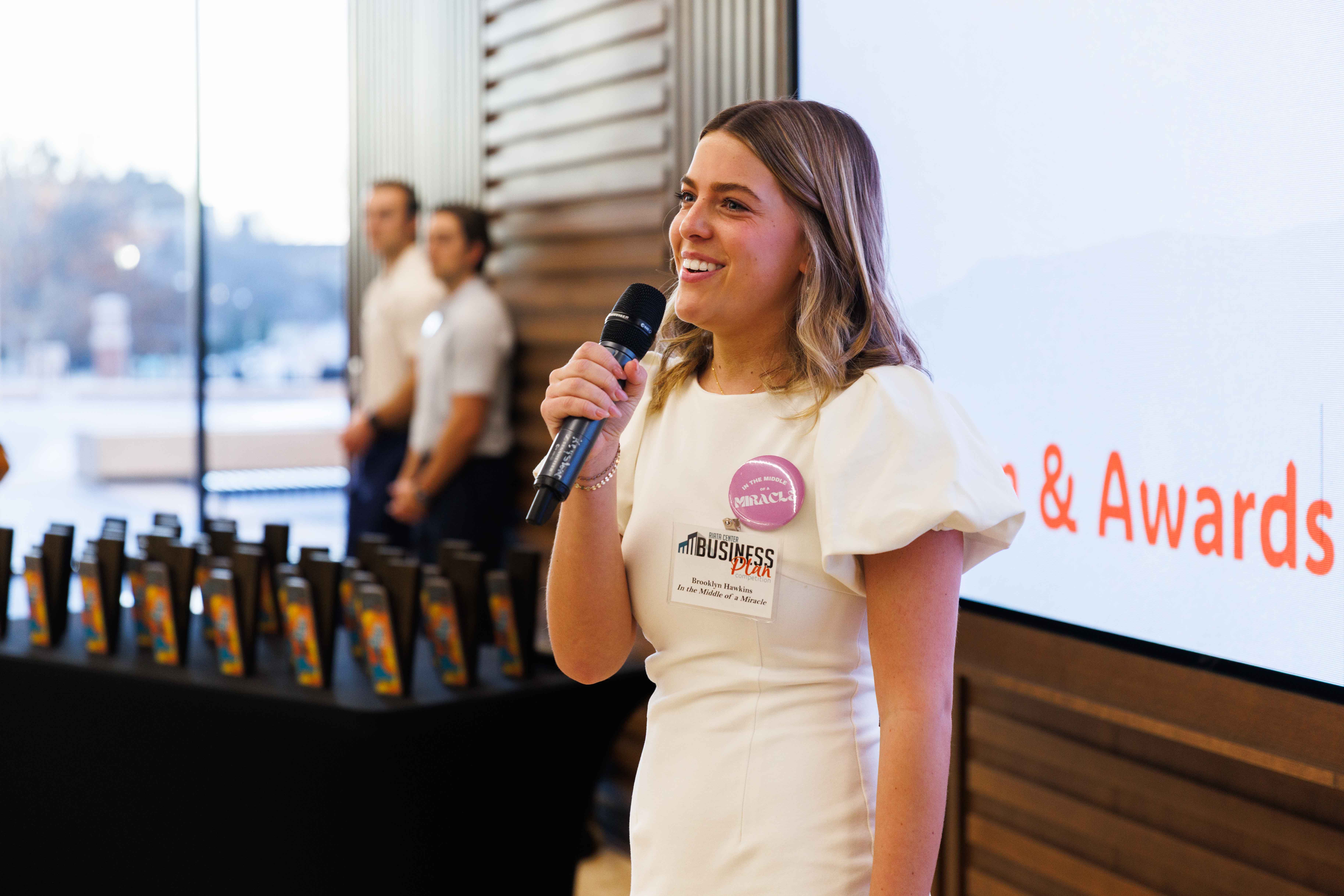Female student speaks at an event with a microphone