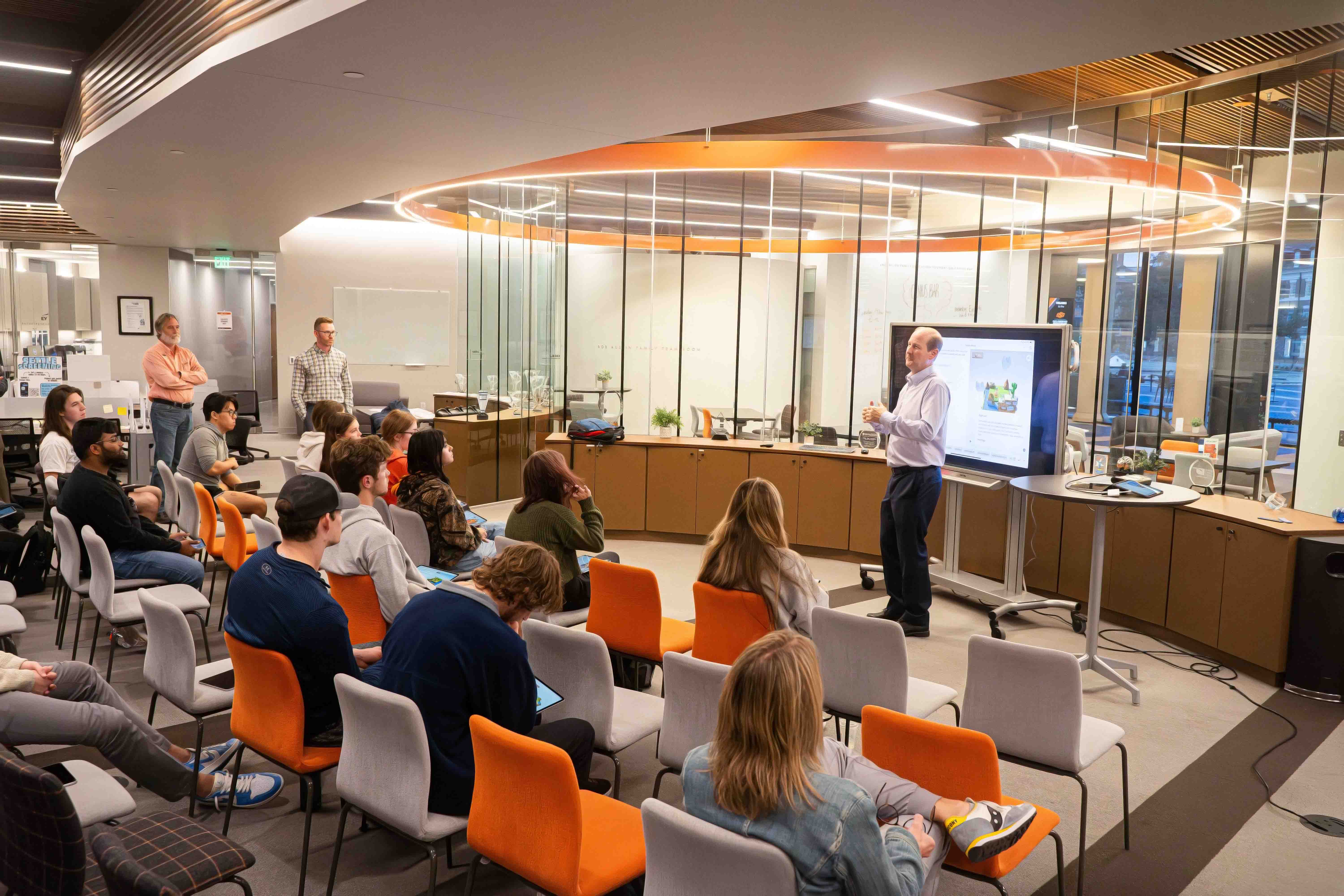 Speaker giving presentation to students in the Riata Center.