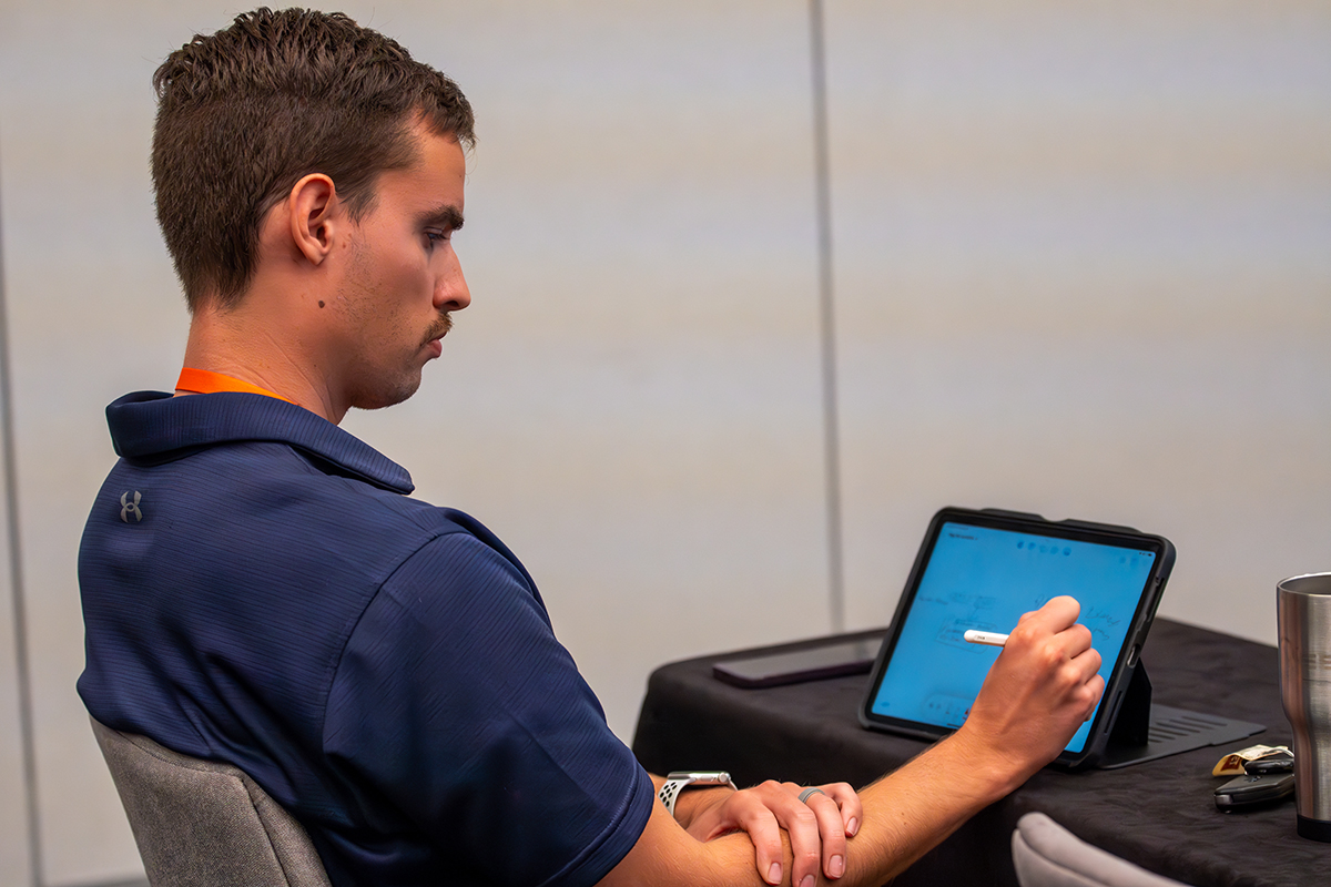 man taking notes on a tablet