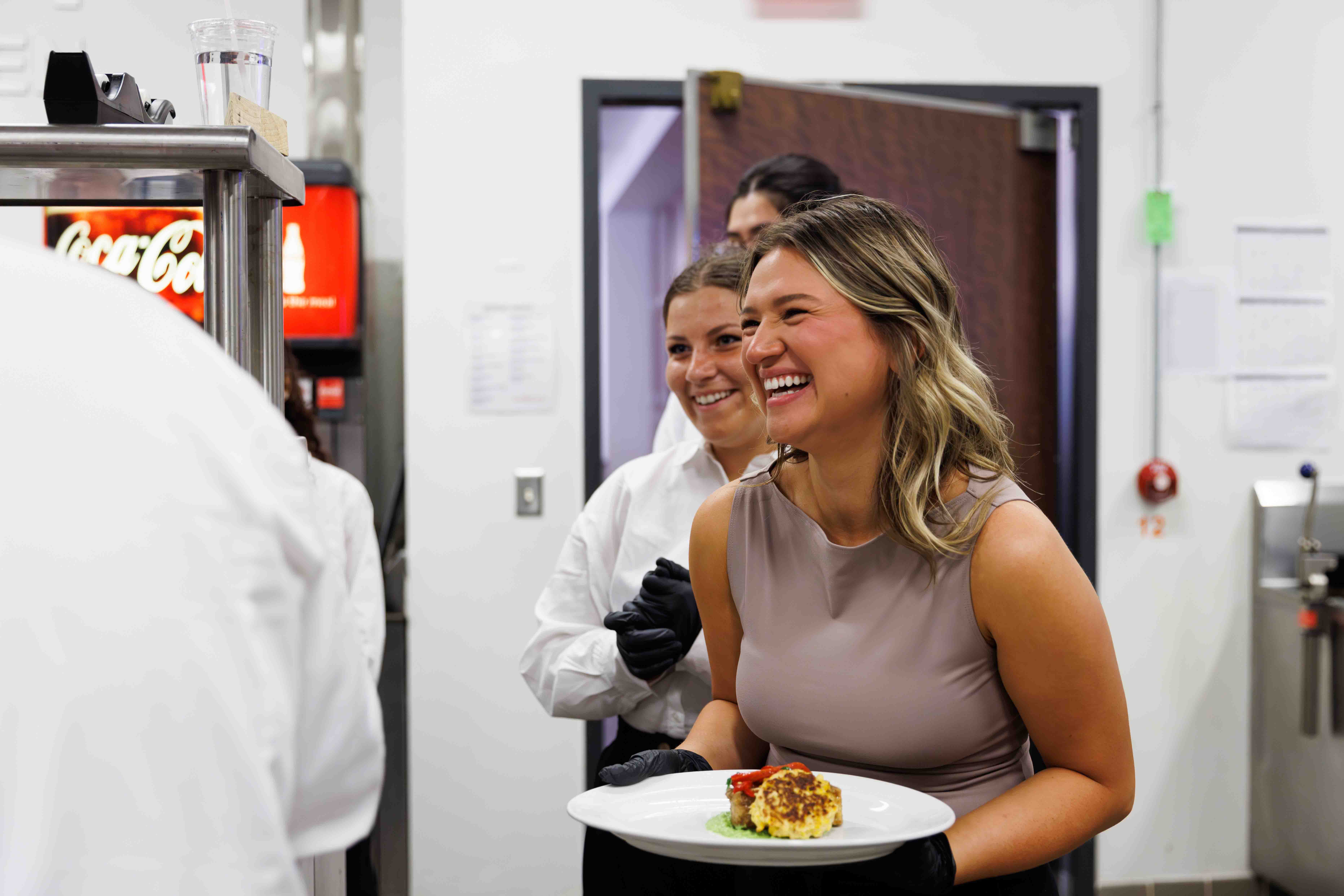 Student smiling while holding a plate of food