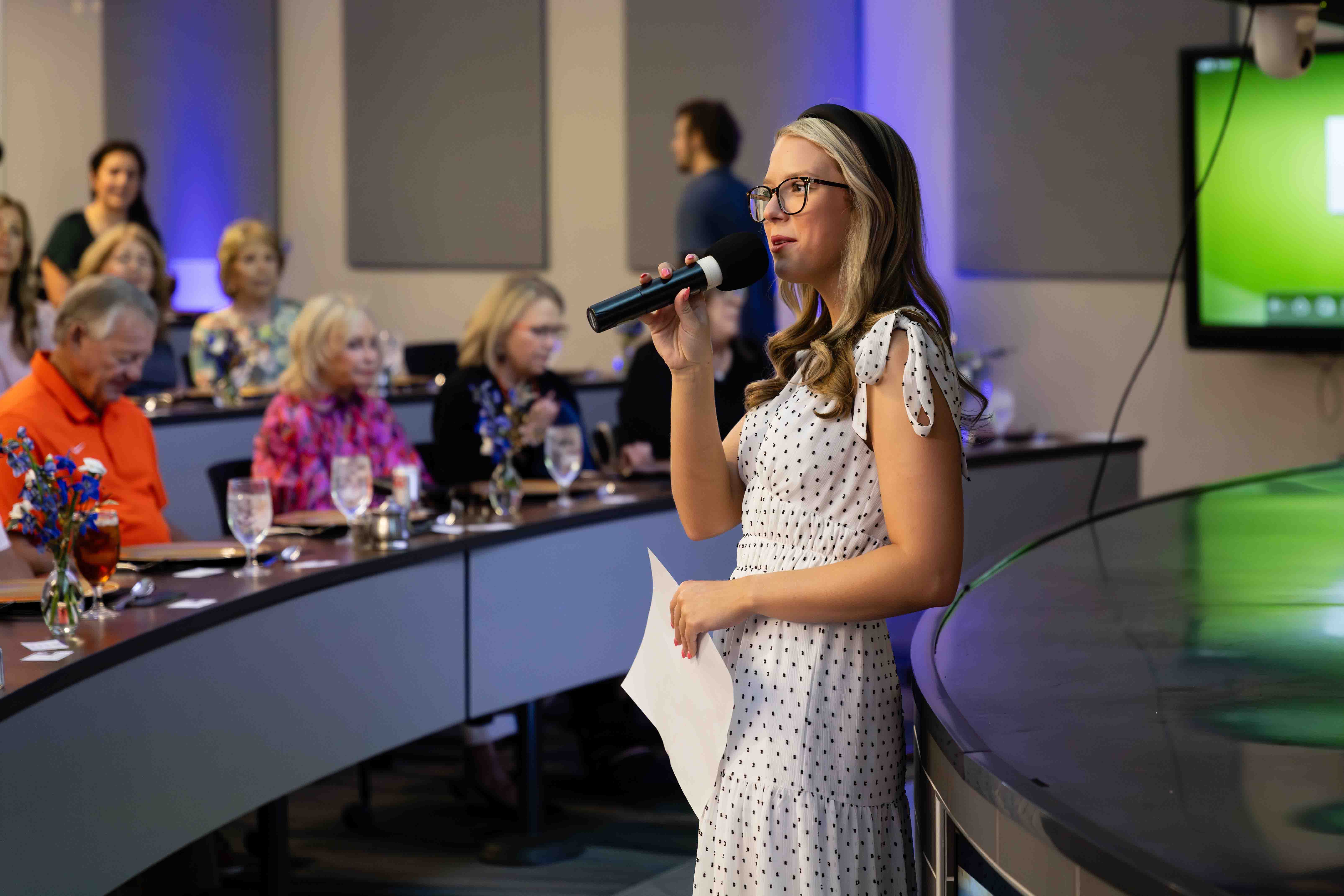 Student worker speaking to guests at Chef Mark Wright's lunch in 2024