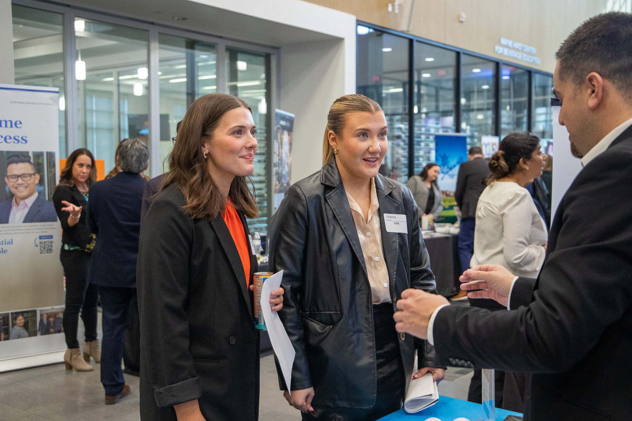 Two female students speaking with a company.