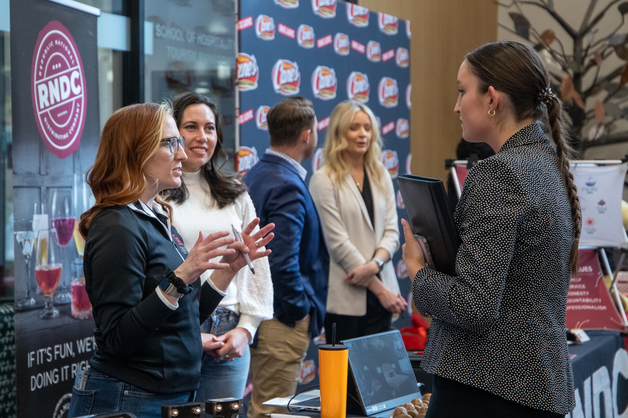 Female student dressed professionally speaking to female recruiter at an RNDC booth.
