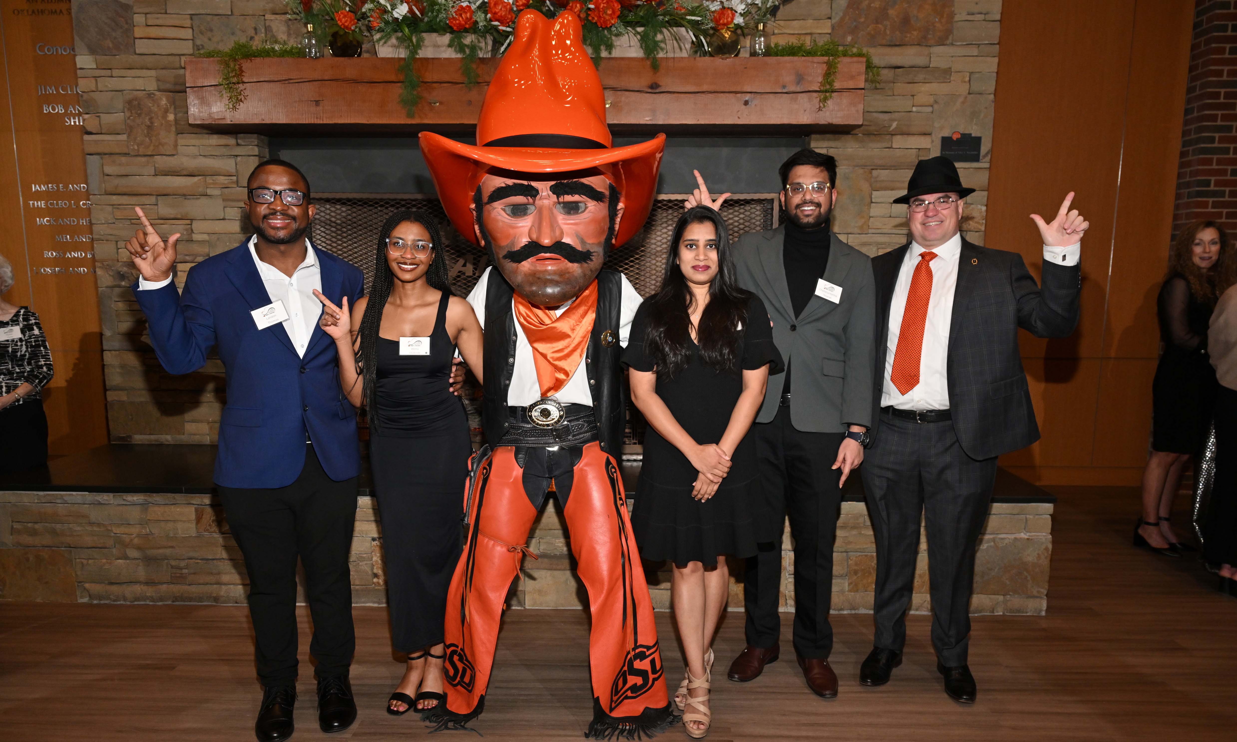 Graduate students and a professor posing with Pistol Pete.