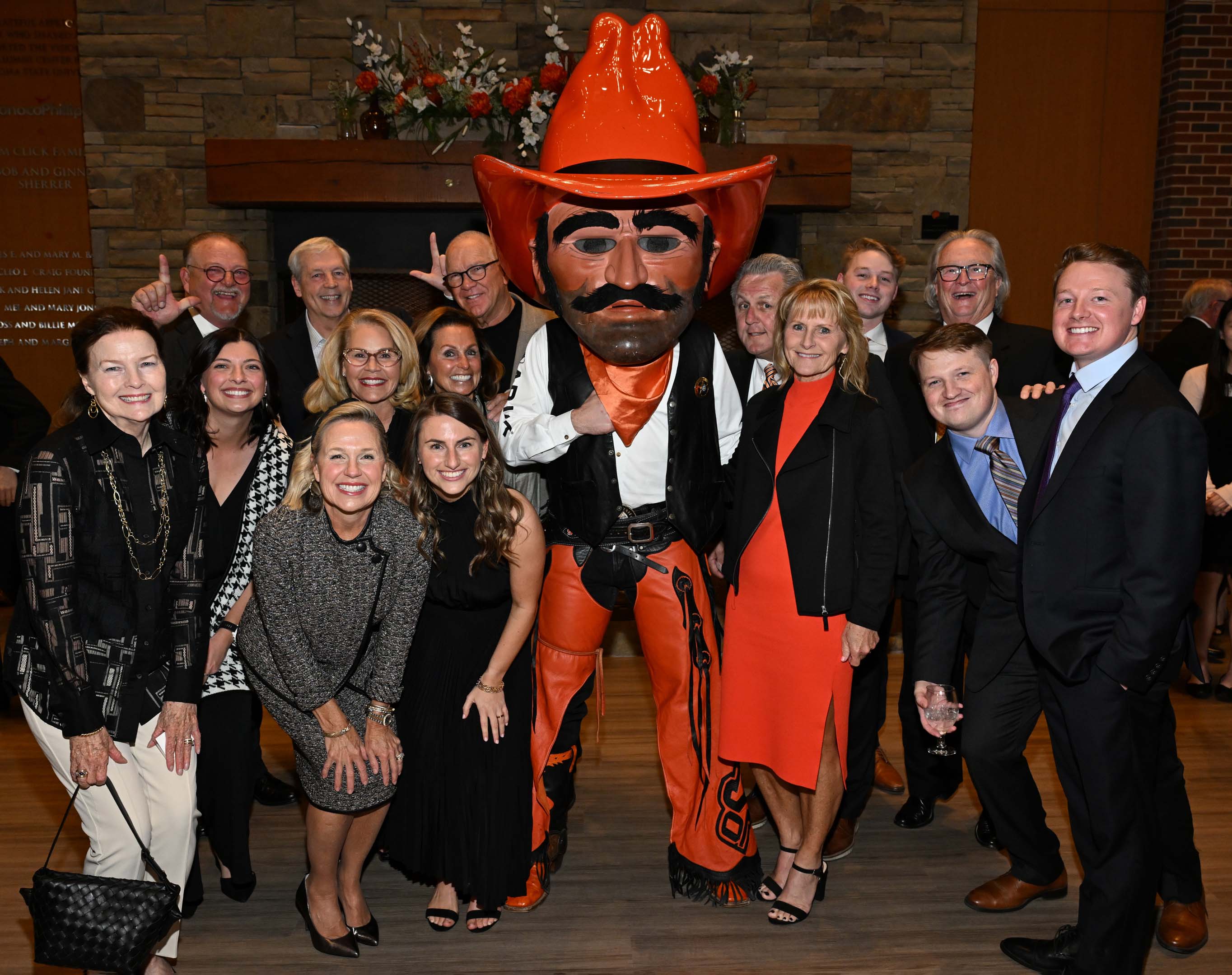 Large family standing with Pistol Pete in the alumni center lobby