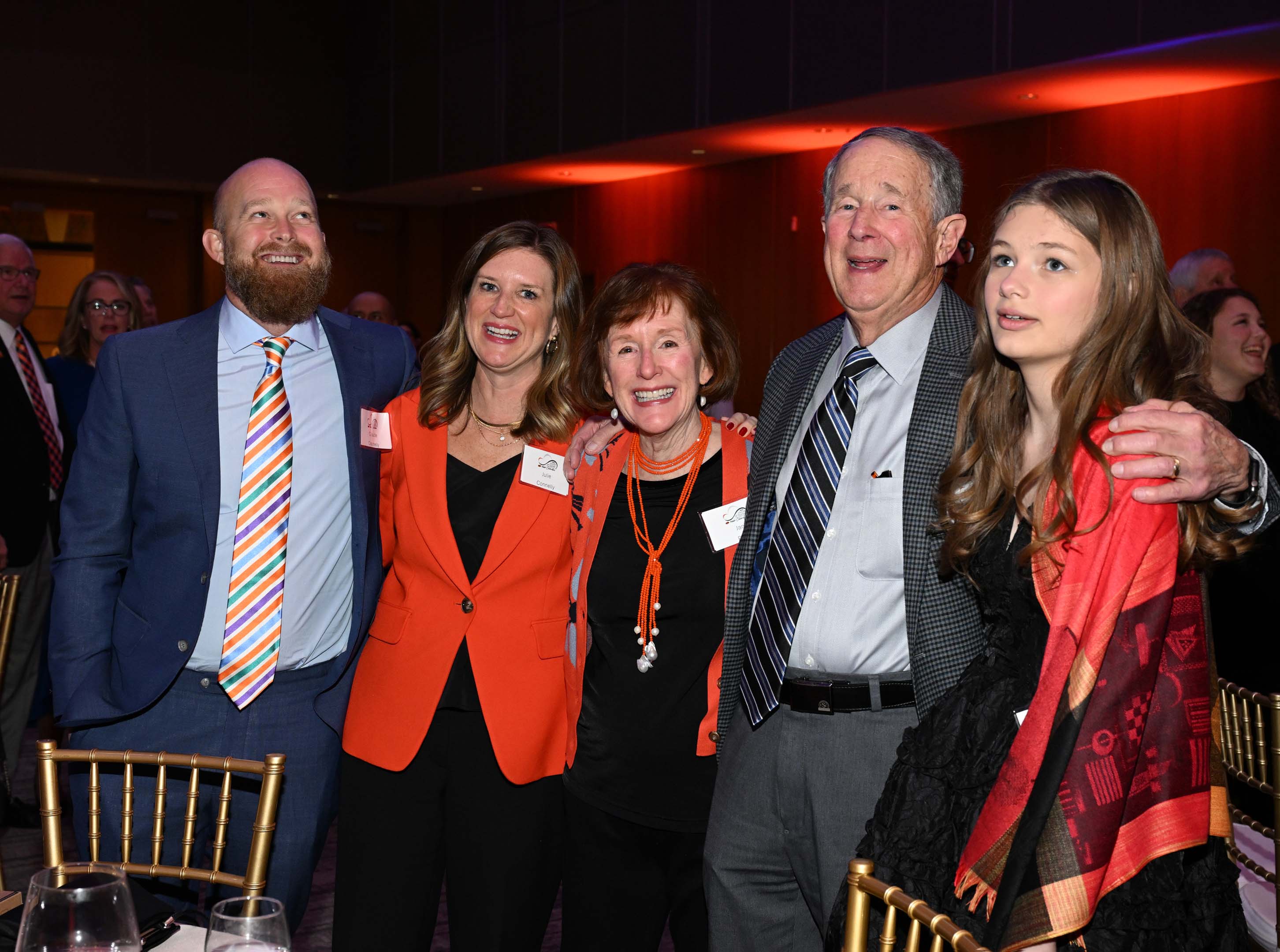 Group of 5 people singing the alma mater and smiling.