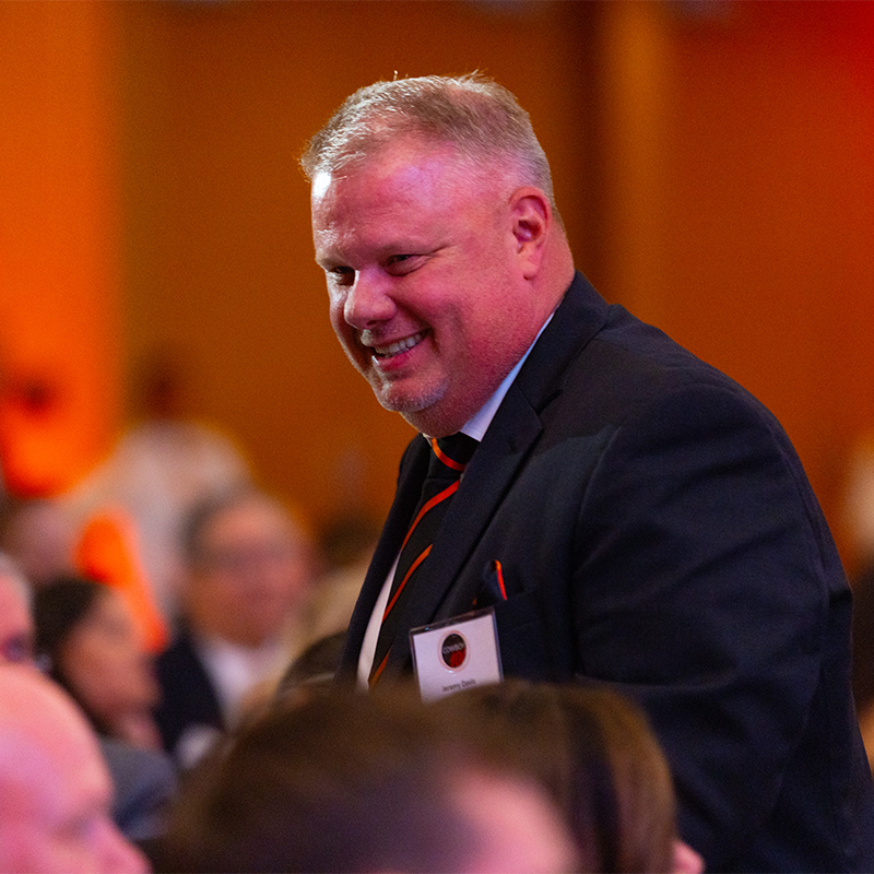 An honoree smiles as he rises from his table to accept his award.